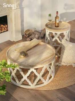 Несколько выдолбленных в стиле ретро круглых деревянных чайных столиков, бревенчатая ветровая мебель в углу дивана в гостиной